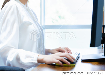 Woman using a computer in the room [parts cut] 105542439