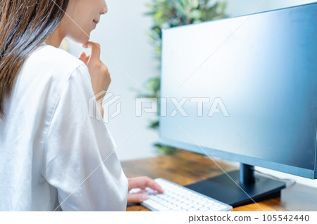 Woman using a computer in the room [parts cut] 105542440