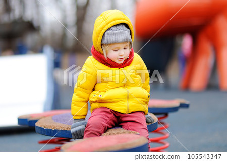 Cute little boy having fun on outdoor playground Cute little boy having fun on outdoor playground 105543347