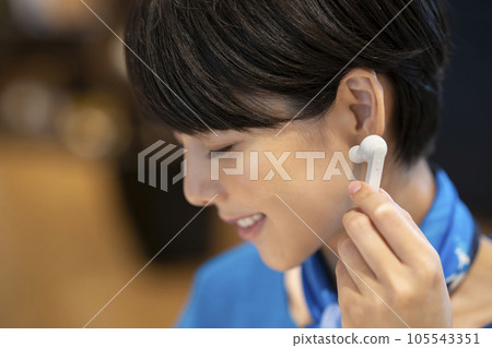 Young woman wearing wireless earphones Photography cooperation: Credisce (Maruzen Yushodo Co., Ltd.) 105543351