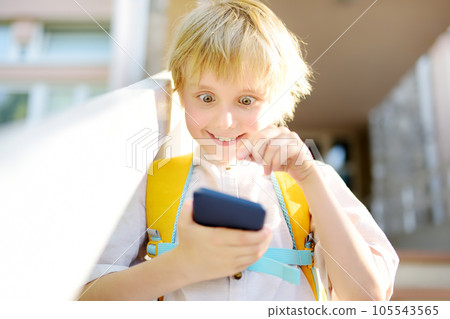Little child is shocked by the information he sees on his smartphone. Inappropriate content for children. For adults only. Boy passionate about computer game from phone. 105543565