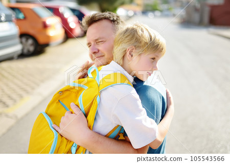 Little boy says goodbye and hugging to his father before going to school. Dad brought his son by car. Education for children. Child is a first day of school. Kids fear. 105543566