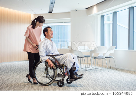 Patient in wheelchair and caregiver 105544095