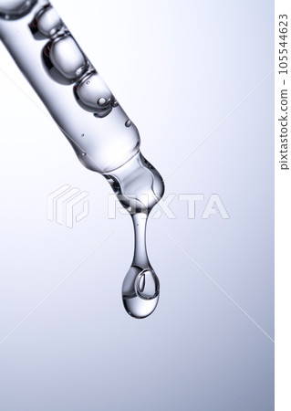 Pipette with serum or other cosmetic product on a blue background. 105544623