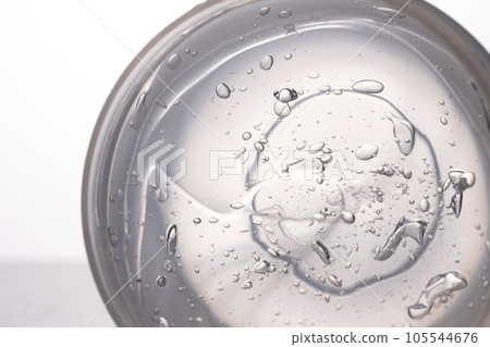 The texture of a thick cosmetic gel on a neutral background. The texture of a thick cosmetic gel on a neutral background. 105544676