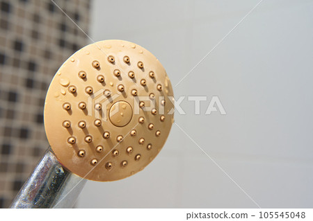 Dirty corroded limescale calcified old shower head hanging from a stand inside cabin 105545048