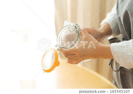 女人擦玻璃瓶的手照片 105545107