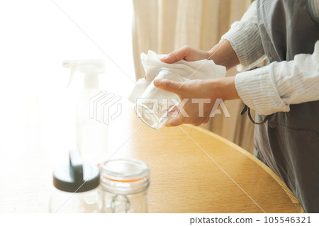 Hand photo of a woman wiping a glass bottle 105546321