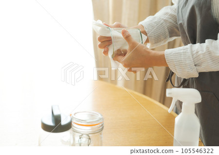 Hand photo of a woman wiping a glass bottle 105546322