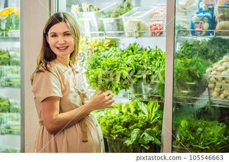 A glowing pregnant woman after forty makes a healthy choice as she selects organic vegetables and fruits at the vibrant organic market, prioritizing her well-being and her baby's health 105546663