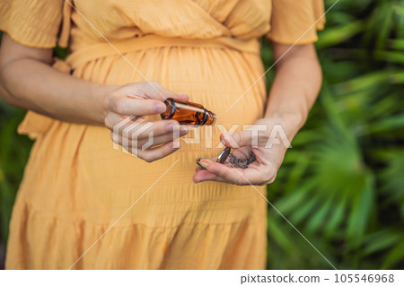 pregnant woman after 40 demonstrating the use of an aroma pendant, combining style and aromatherapy during her pregnancy journey pregnant woman after 40 demonstrating the use of an aroma pendant, combining style and aromatherapy during her pregnancy journey 105546968