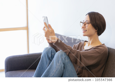 一個女人坐在沙發上和放鬆 105547366