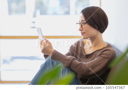 一個女人坐在沙發上和放鬆 105547367