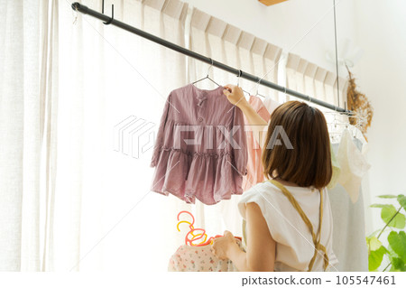 A woman drying laundry indoors 105547461