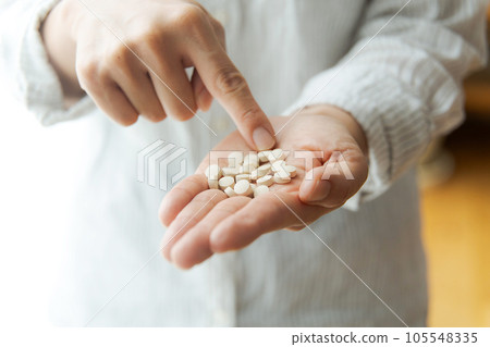 Hand photo of a woman with supplements 105548335