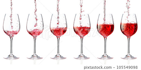 Pouring pink wine into a glass on a white background. 105549098