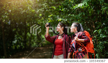 Two hikers with backpacks walking in the forest 105549367