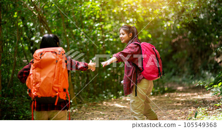 Two hikers with backpacks walking in the forest 105549368