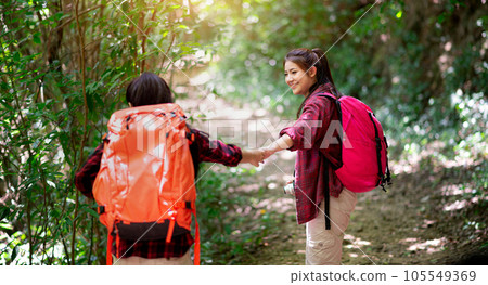 Two hikers with backpacks walking in the forest 105549369