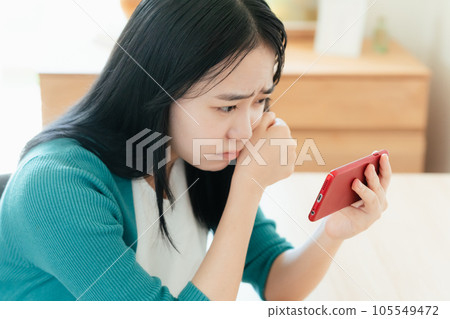 在智能手機上觀看視頻的年輕女子 在智能手機上觀看視頻的年輕女子 105549472