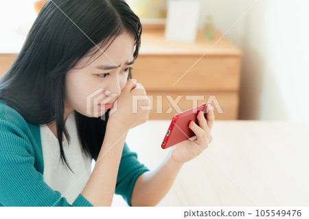 Young woman watching video on smartphone Young woman watching video on smartphone 105549476