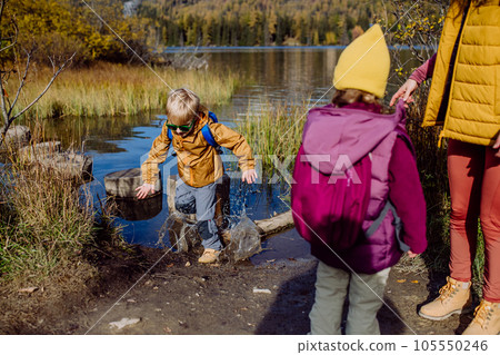 Little boy slipping on wet shore around the lake. Little boy slipping on wet shore around the lake. 105550246