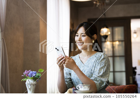 A woman using her smartphone in a cafe 105550264