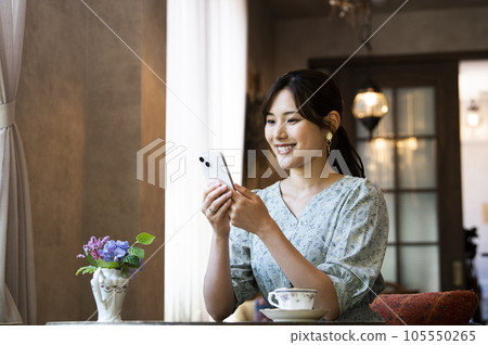 A woman using her smartphone in a cafe 105550265