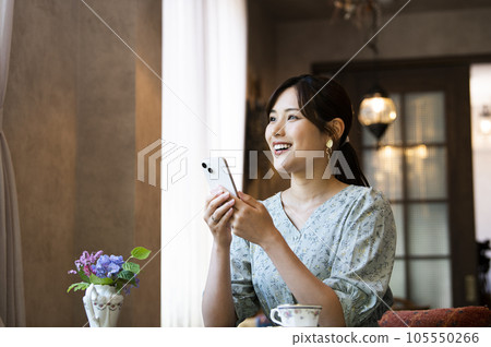 A woman using her smartphone in a cafe 105550266