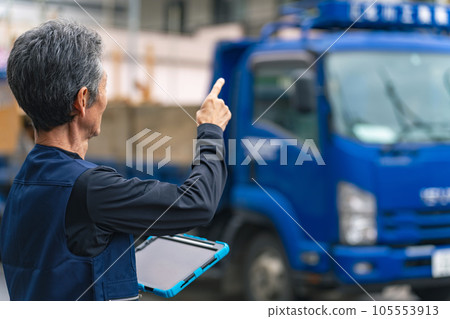 A craftsman holding a tablet and inspecting the construction site 105553913
