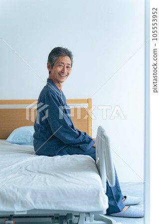 Smiling senior man sitting on the bed Smiling senior man sitting on the bed 105553952