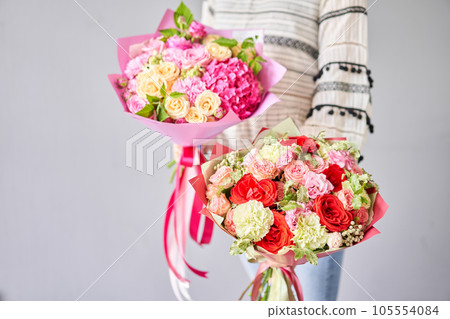 Two Small Beautiful bouquets of mixed flowers in woman hand. Floral shop concept . Beautiful fresh cut bouquet. Flowers delivery Two Small Beautiful bouquets of mixed flowers in woman hand. Floral shop concept . Beautiful fresh cut bouquet. Flowers delivery 105554084