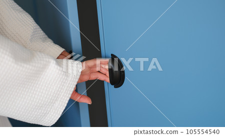 Female hands open doors of blue stylish closet at home Female hands open doors of blue stylish closet at home 105554540
