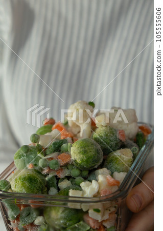 Unrecognizable woman showing Frozen mixed vegetables homemade. Harvesting concept. Stocking up vegetables for winter storage Unrecognizable woman showing Frozen mixed vegetables homemade. Harvesting concept. Stocking up vegetables for winter storage 105555606