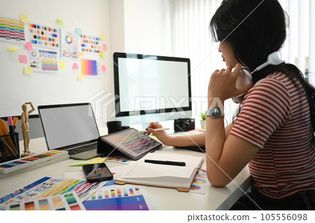 Young creative woman working with color palette, choosing color samples for design project at graphic studio. Young creative woman working with color palette, choosing color samples for design project at graphic studio. 105556098