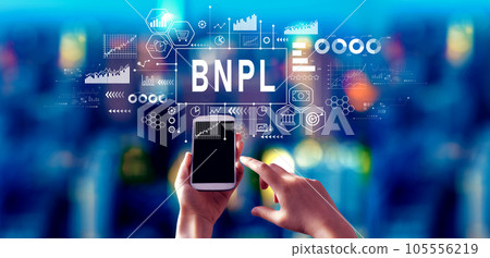 BNPL - Buy Now Pay Later theme with person using a smartphone at night BNPL - Buy Now Pay Later theme with person using a smartphone at night 105556219
