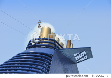 Beautiful cruise ship top with chimneys and small white smoke against blue sky 105556797