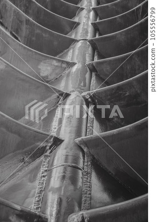 Pieces of smooth metal are welded to the metal axis at regular intervals.Black and white abstraction 105556799