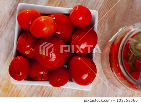Juicy marinated tomatoes on a white plate. Homemade canning.  105558566