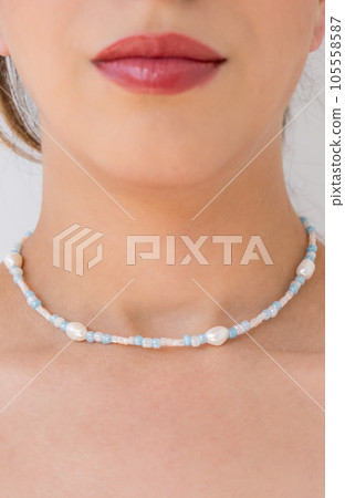Young woman wearing a necklace with beads. Young woman wearing a necklace with beads. 105558587