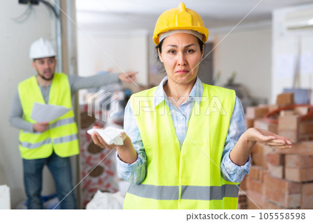 Puzzled female construction worker with displeased screaming foreman Puzzled female construction worker with displeased screaming foreman 105558598