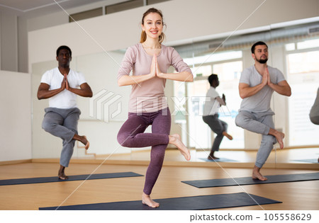 Woman standing in Eka Pada Utkatasana with hands in namaste 105558629