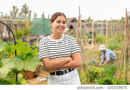 Young woman gardener standing in her farm smiling 105558670