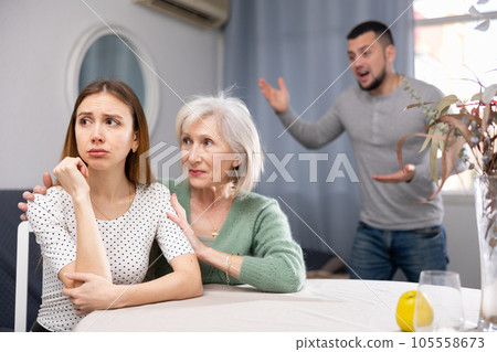Elderly mother comforts her adult daughter after her quarrel with husband 105558673