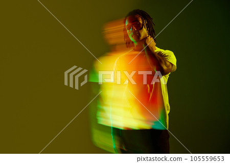 Stylish you guy with dress posing in casual clothes in gradient green background in neon light. Mixed light effect 105559653