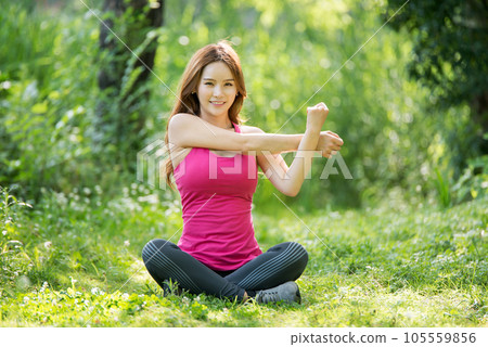 young woman doing yoga in park 105559856
