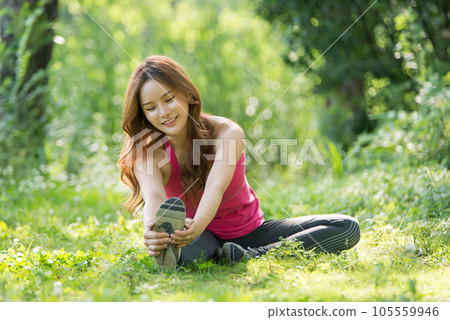 young woman doing yoga in park 105559946