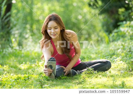 young woman doing yoga in park 105559947