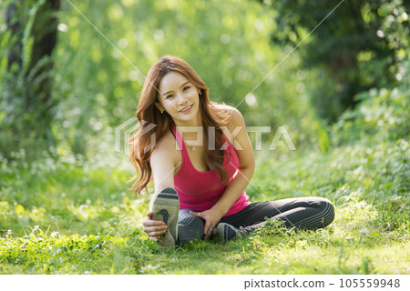 young woman doing yoga in park 105559948