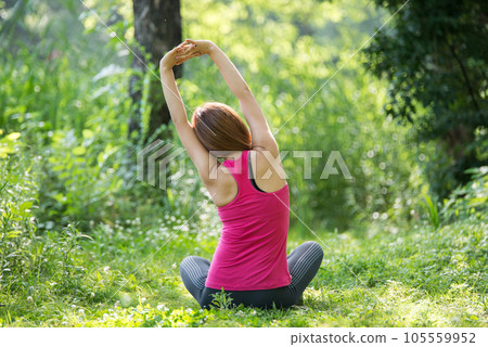 young woman doing yoga in park 105559952